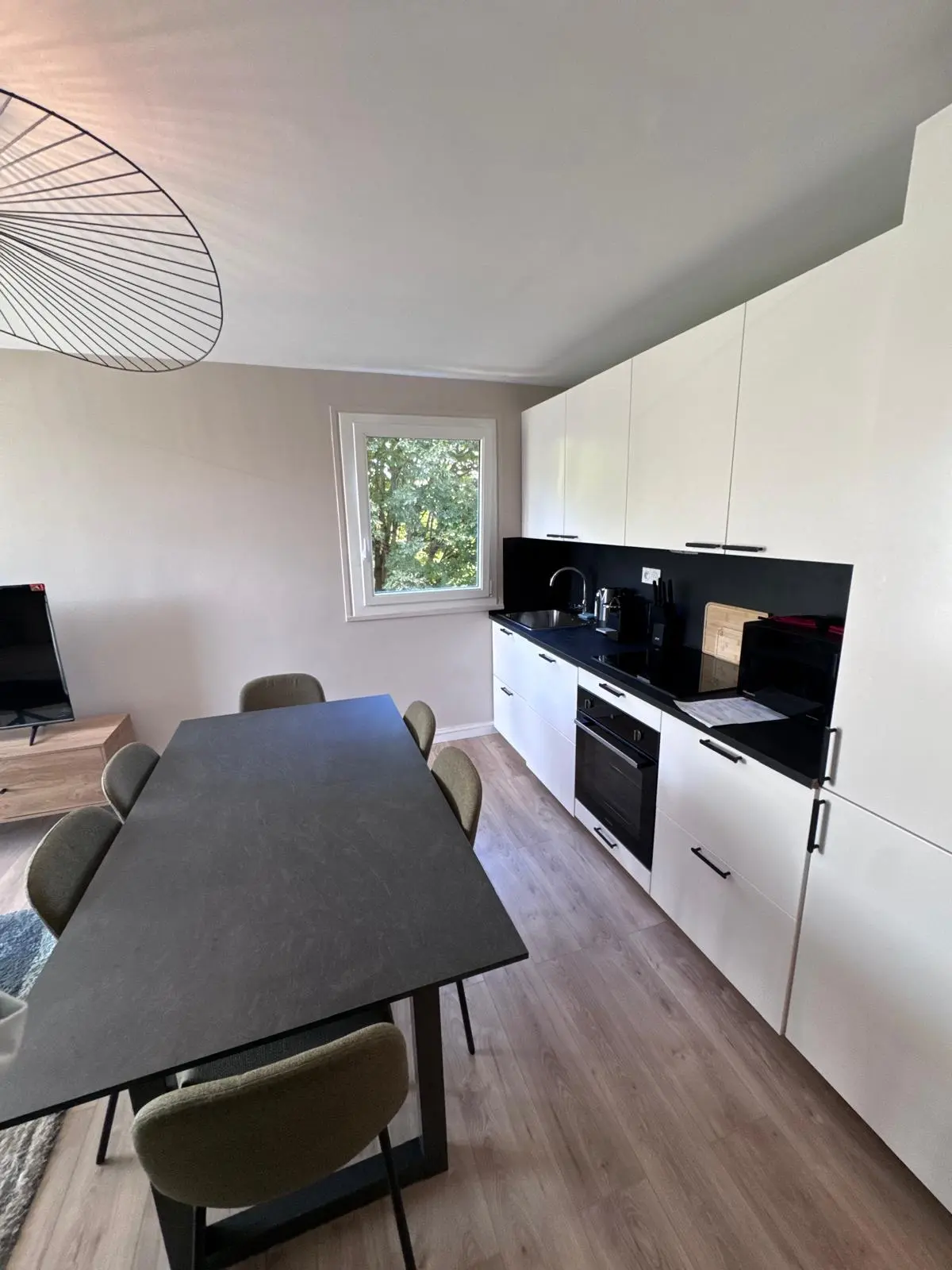 Cuisine ouverte avec espace repas après rénovation à Noisy-le-Sec