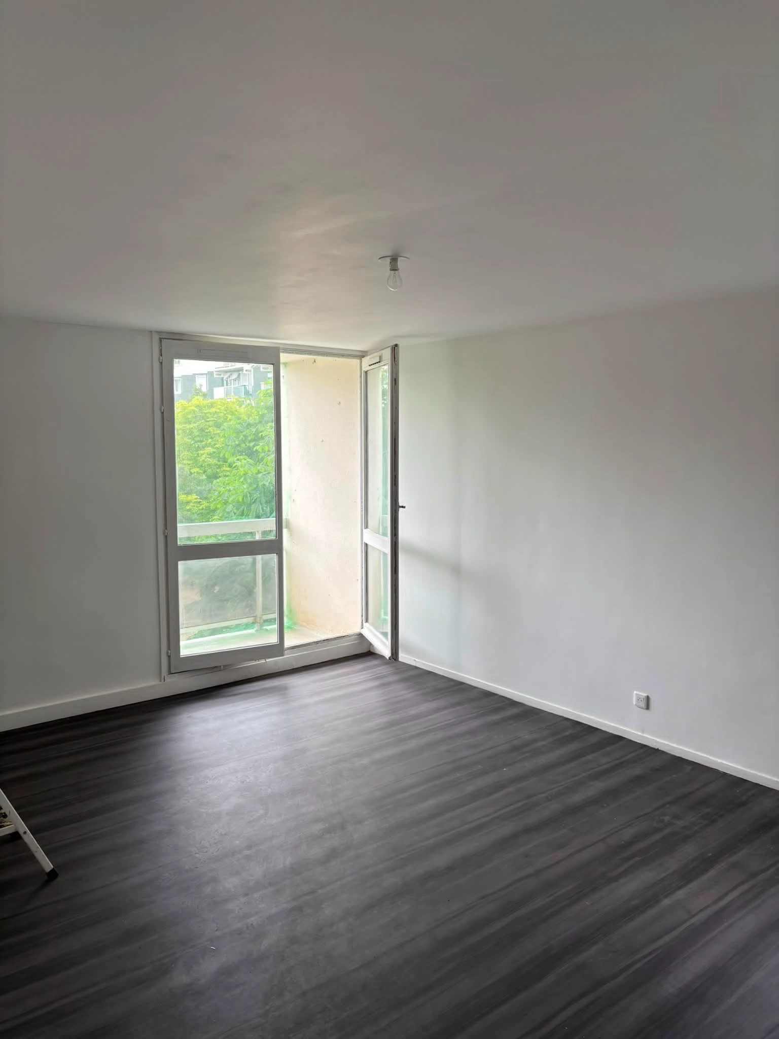 Séjour avec balcon avant rénovation de la colocation à Noisy-le-Sec